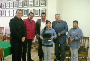 Entrega de computadora portátil a estudiante sobresaliente